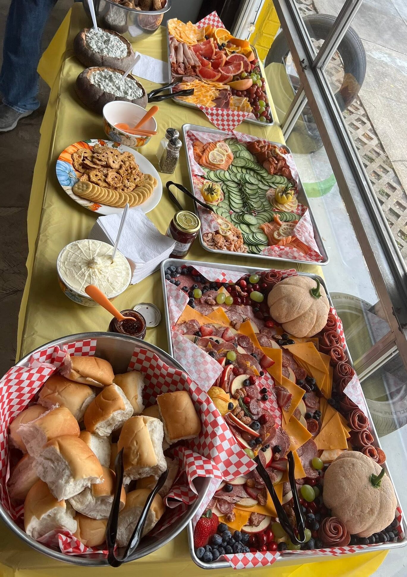 A party spread of sliders, charcuterie and dips on a long table