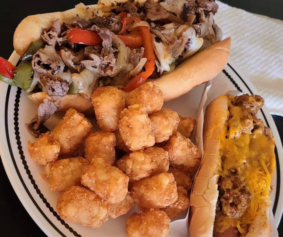Steak hoagie, tots and a chili cheese dog on a plate