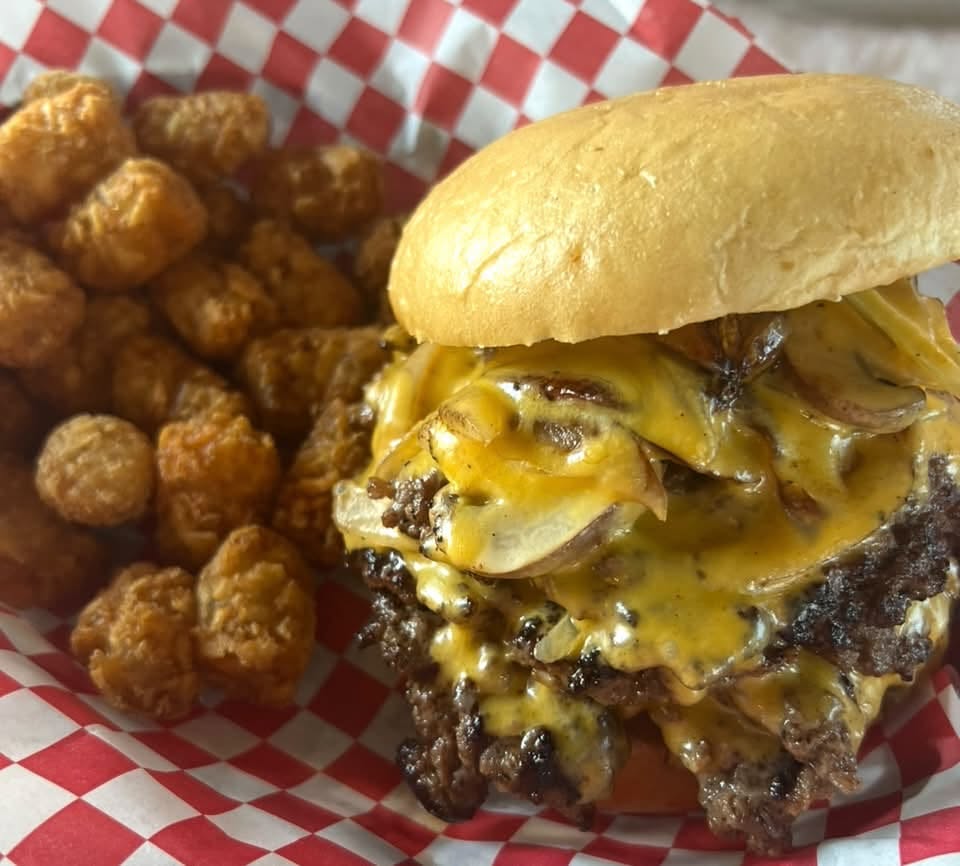 Cheesy smash burger with tots on checkered paper