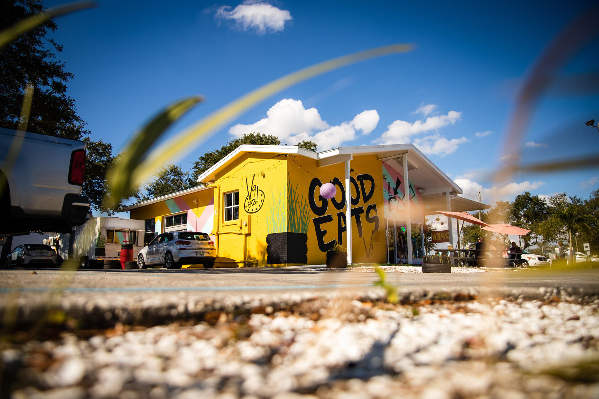 The sunflower-yellow V9 EATS building, the converted service station on 9th Ave N, under a blue St. Pete sky