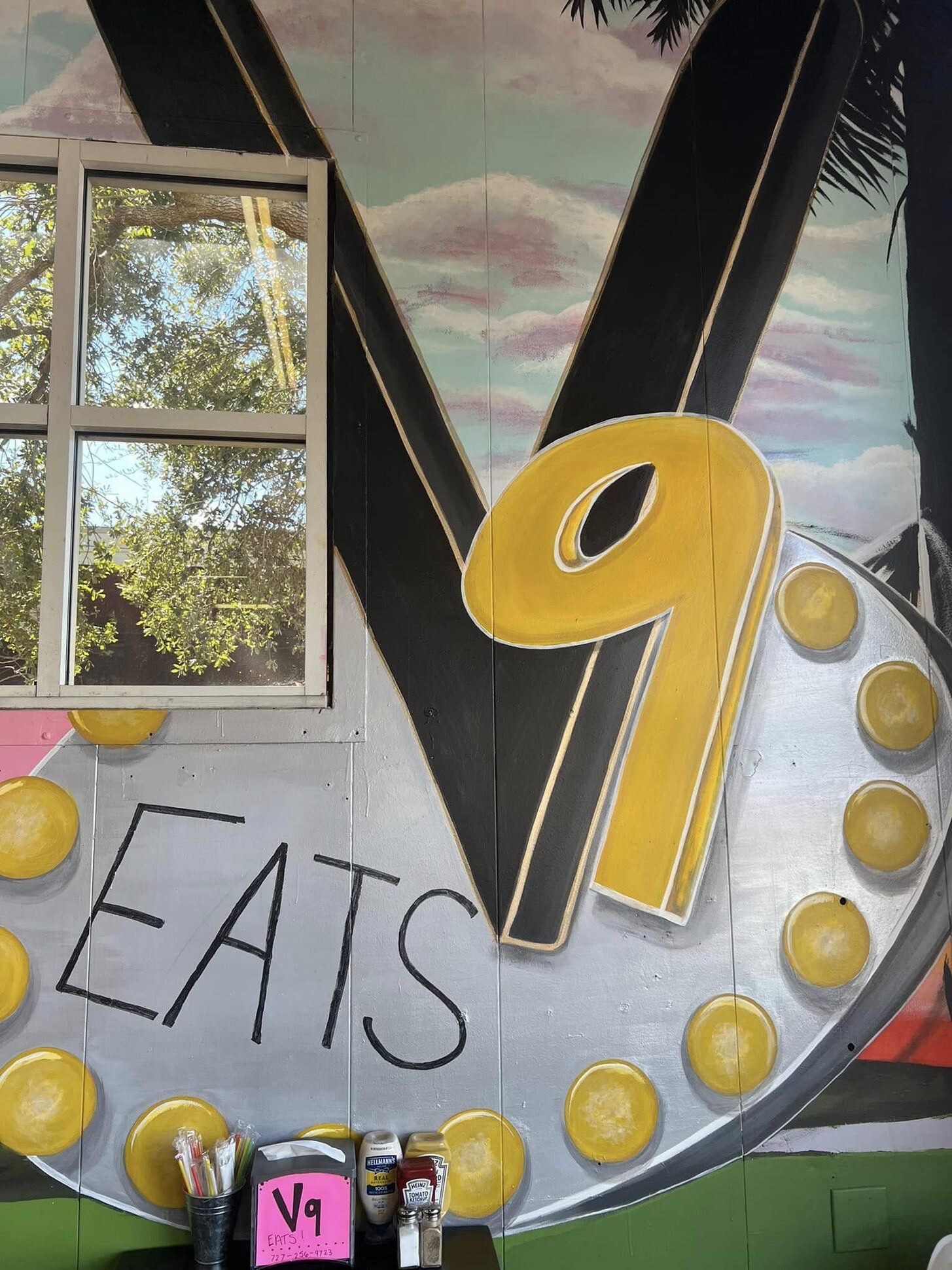 The marquee V9 EATS sign on the dining-room wall