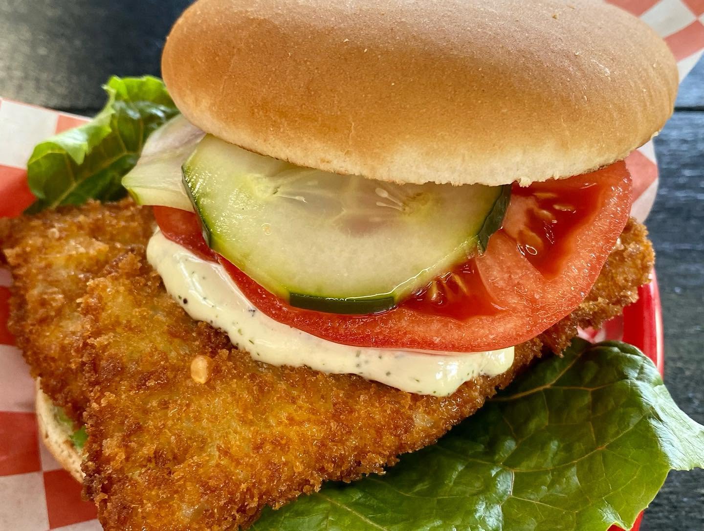 Fried schnitzel sandwich with tomato and cucumber