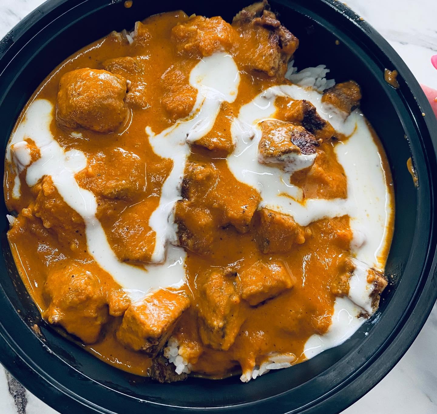 Indian Butter Chicken over rice with yogurt drizzle